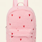 A pink teddy fleece backpack with small red heart details and a front flap pocket, shown on a plain white background.